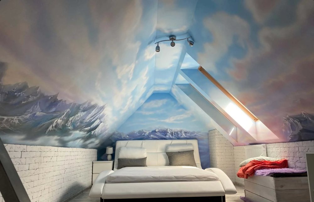 Mural malowany ręcznie na poddaszu – niebo i góry w sypialni