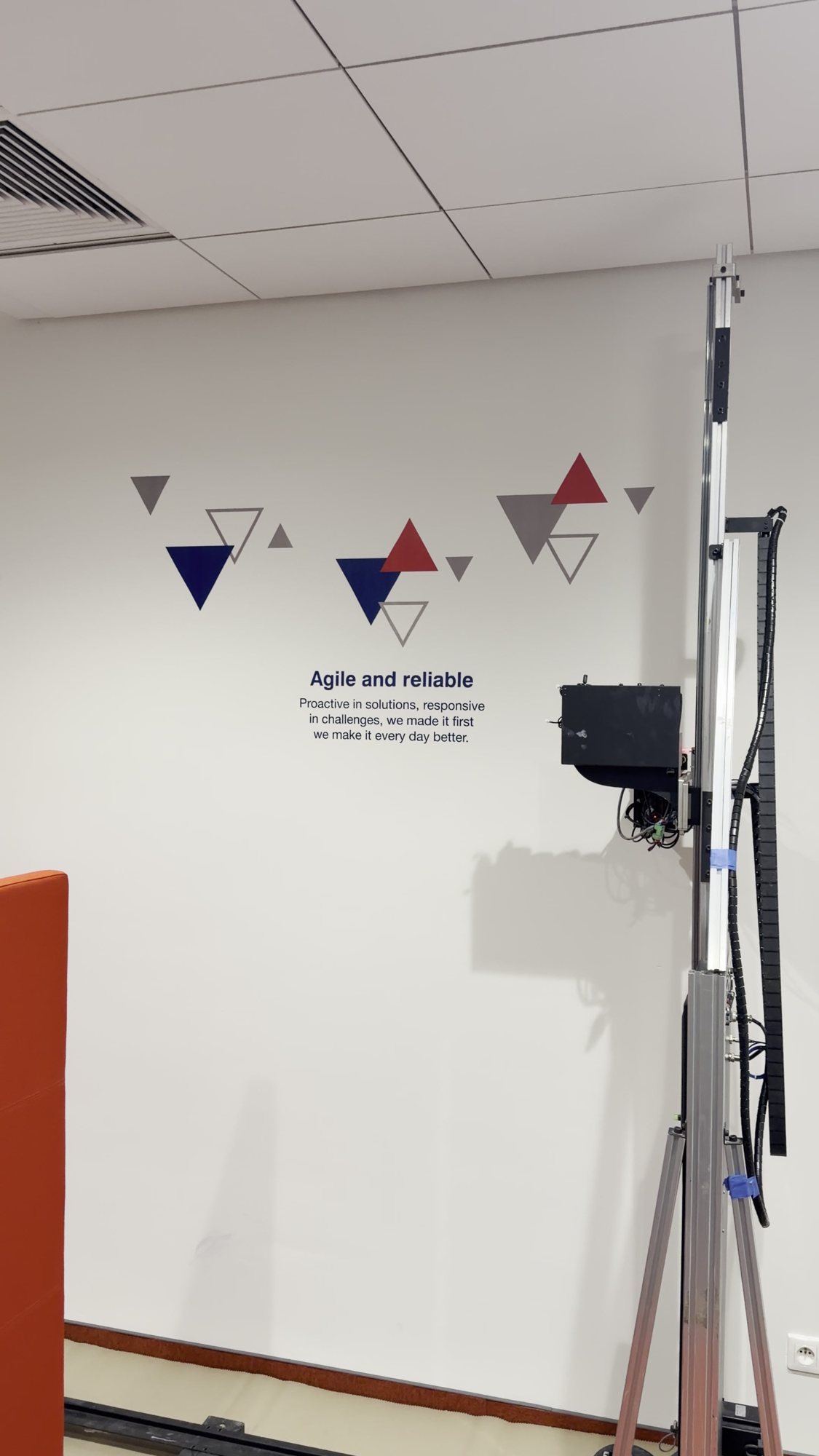 Grafika z trójkątami i hasłem Agile and reliable wydrukowana na ścianie biura Leasys