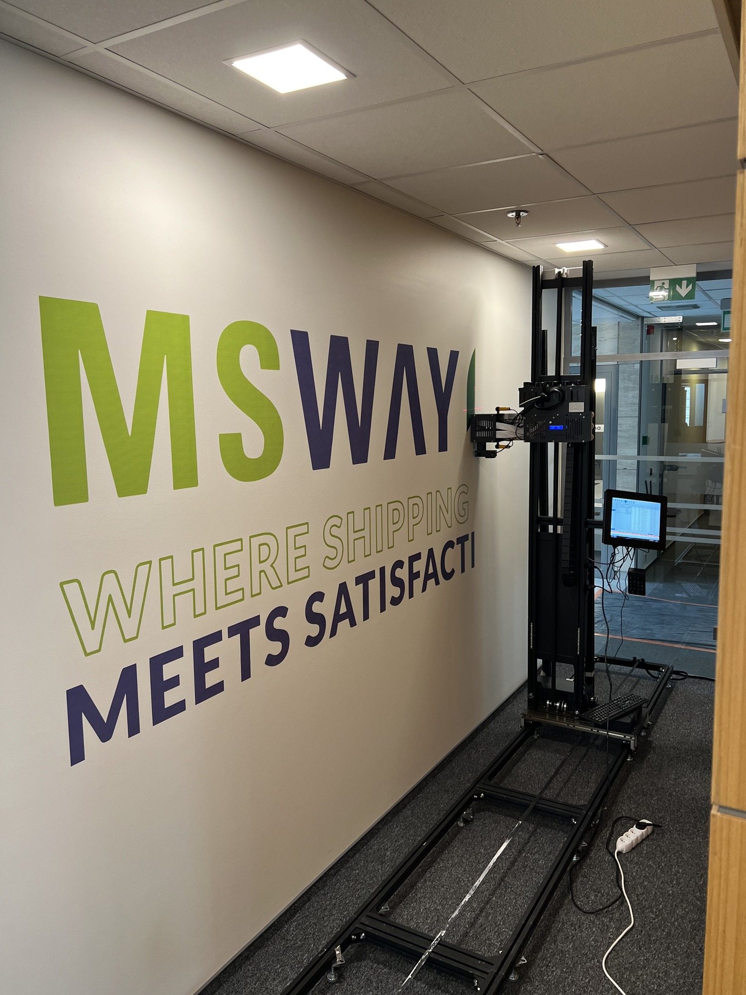 Logo MS WAY z hasłem Where shipping meets satisfaction wydrukowane UV na ścianie przy wejściu do biura, ok. 5 m²