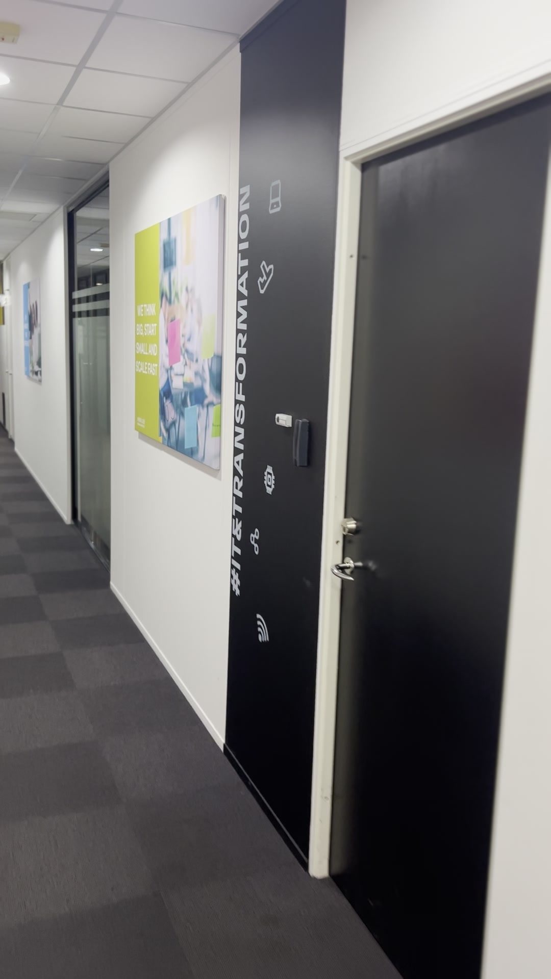 Czarna ściana z napisem #IT TRANSFORMATION na korytarzu biura RCI Bank