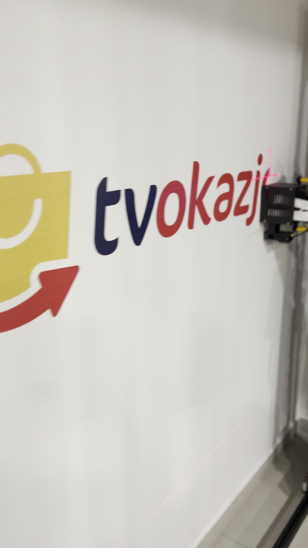 Drukarka ścienna UV drukuje logo tvokazje na ścianie biura w Gdańsku