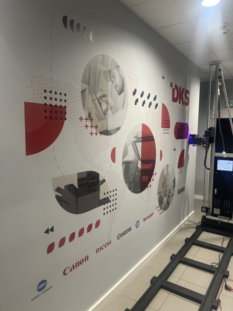 Druk ścienny UV w biurze DKS w Gdańsku – logo i zdjęcia w kołach