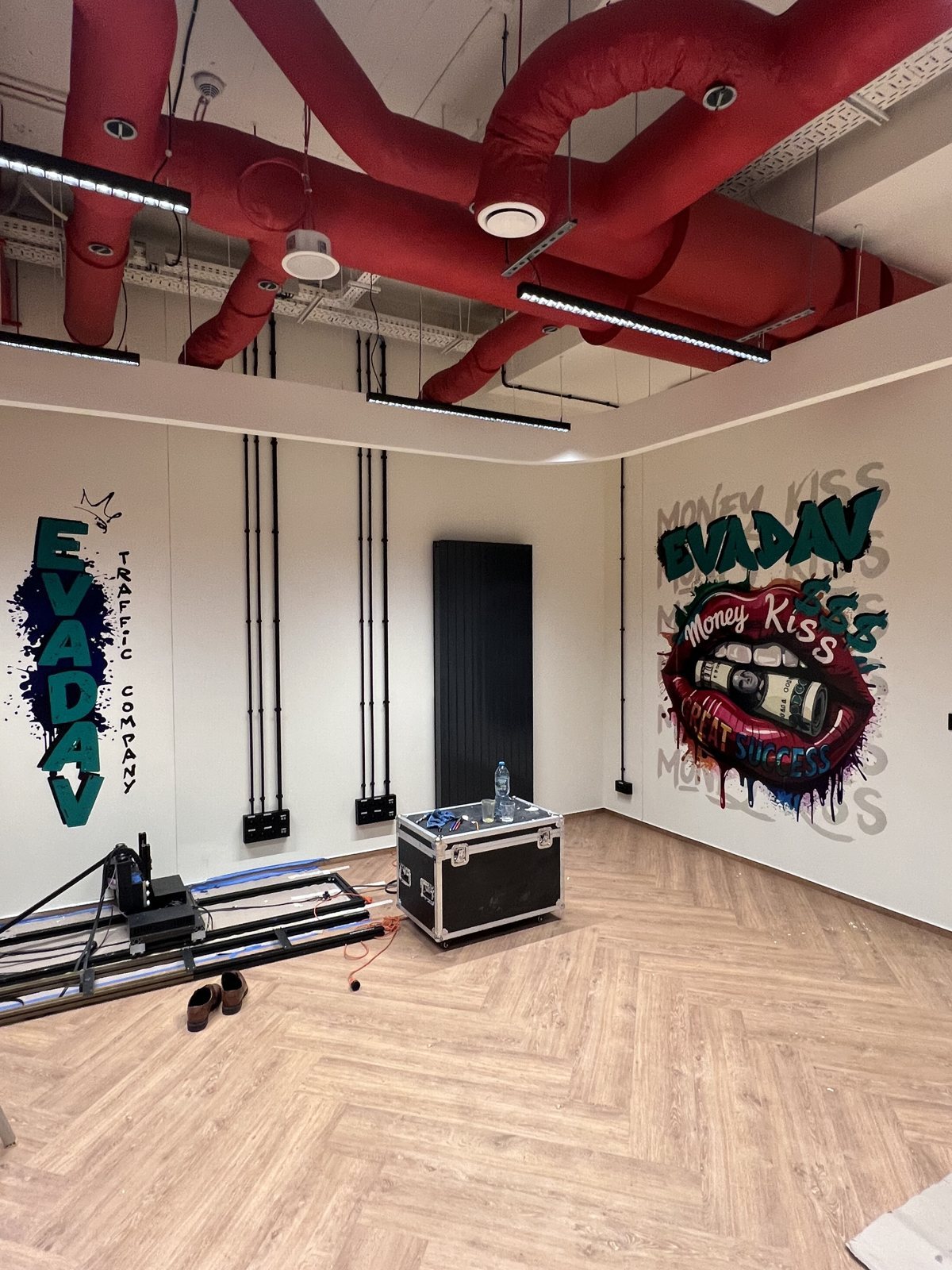 Sala w biurze Eva Dav z pionowym logo i drukiem ust Money Kiss na ścianie