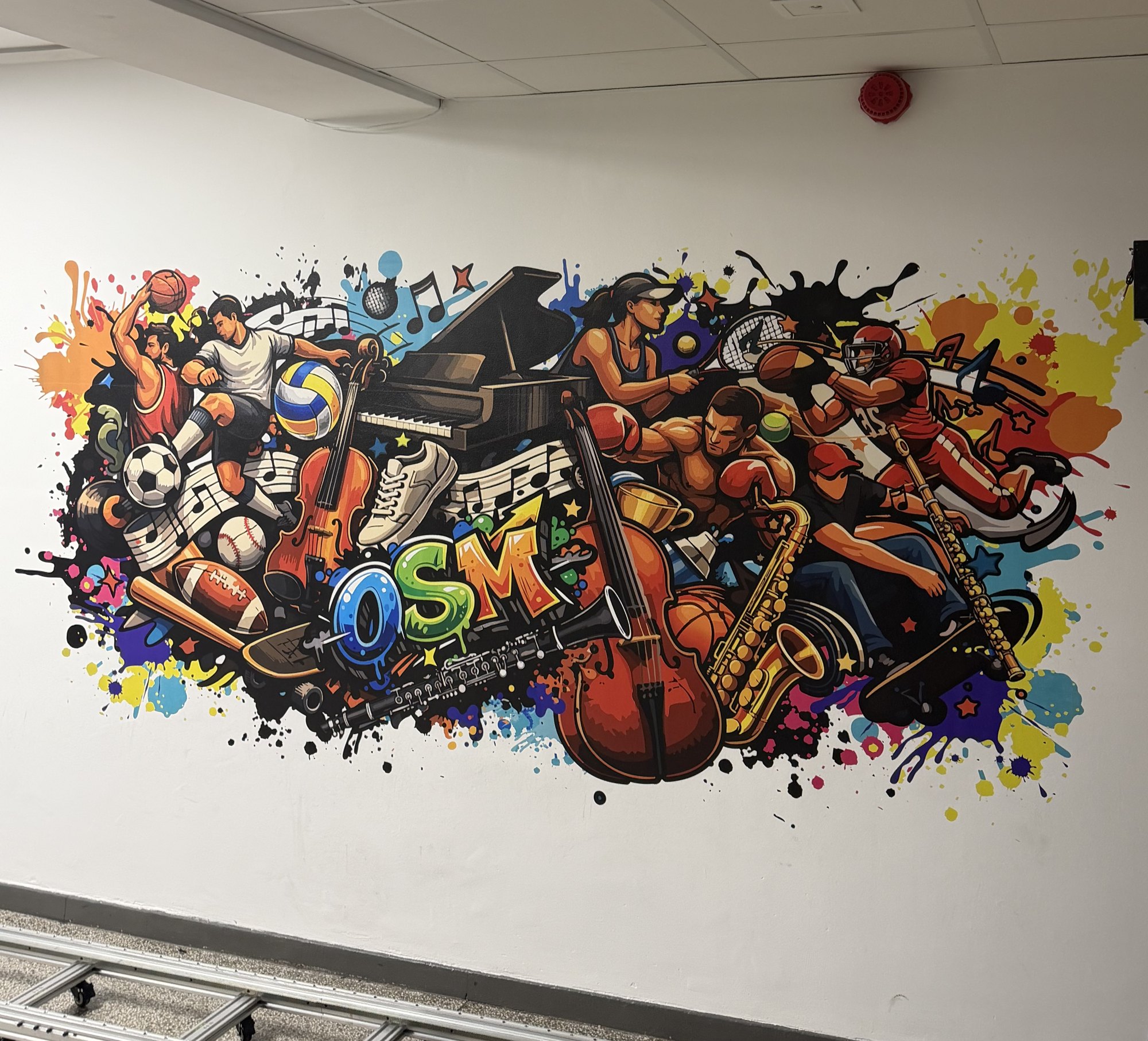 Kolorowy mural sport i muzyka z napisem OSM na ścianie korytarza szkoły muzycznej w Gdańsku – druk ścienny UV