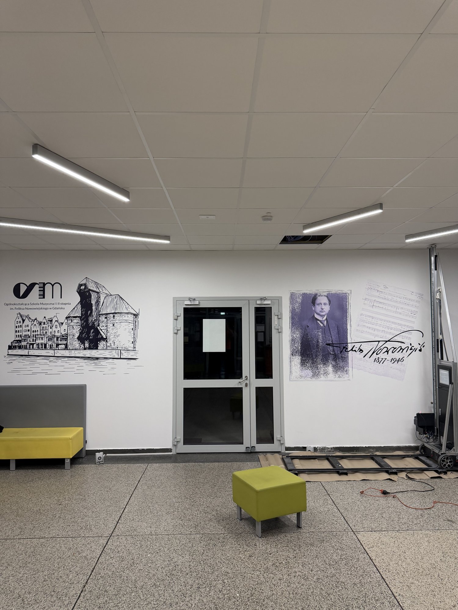 Odnowiony hol szkoły muzycznej w Gdańsku – logo OSM z Żurawiem i portret Feliksa Nowowiejskiego na ścianach